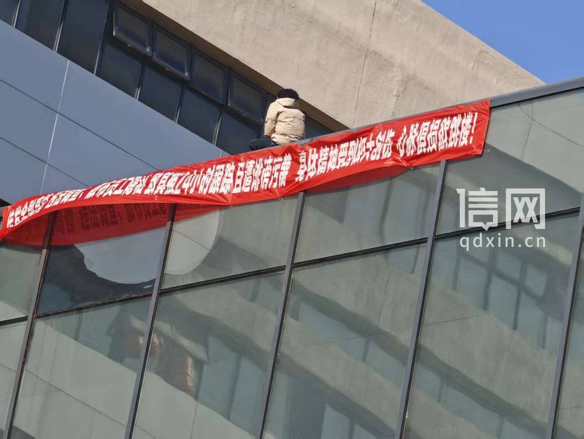南昌一女子挂横幅欲跳楼 涉事企业称当事人已离职两年动机不明